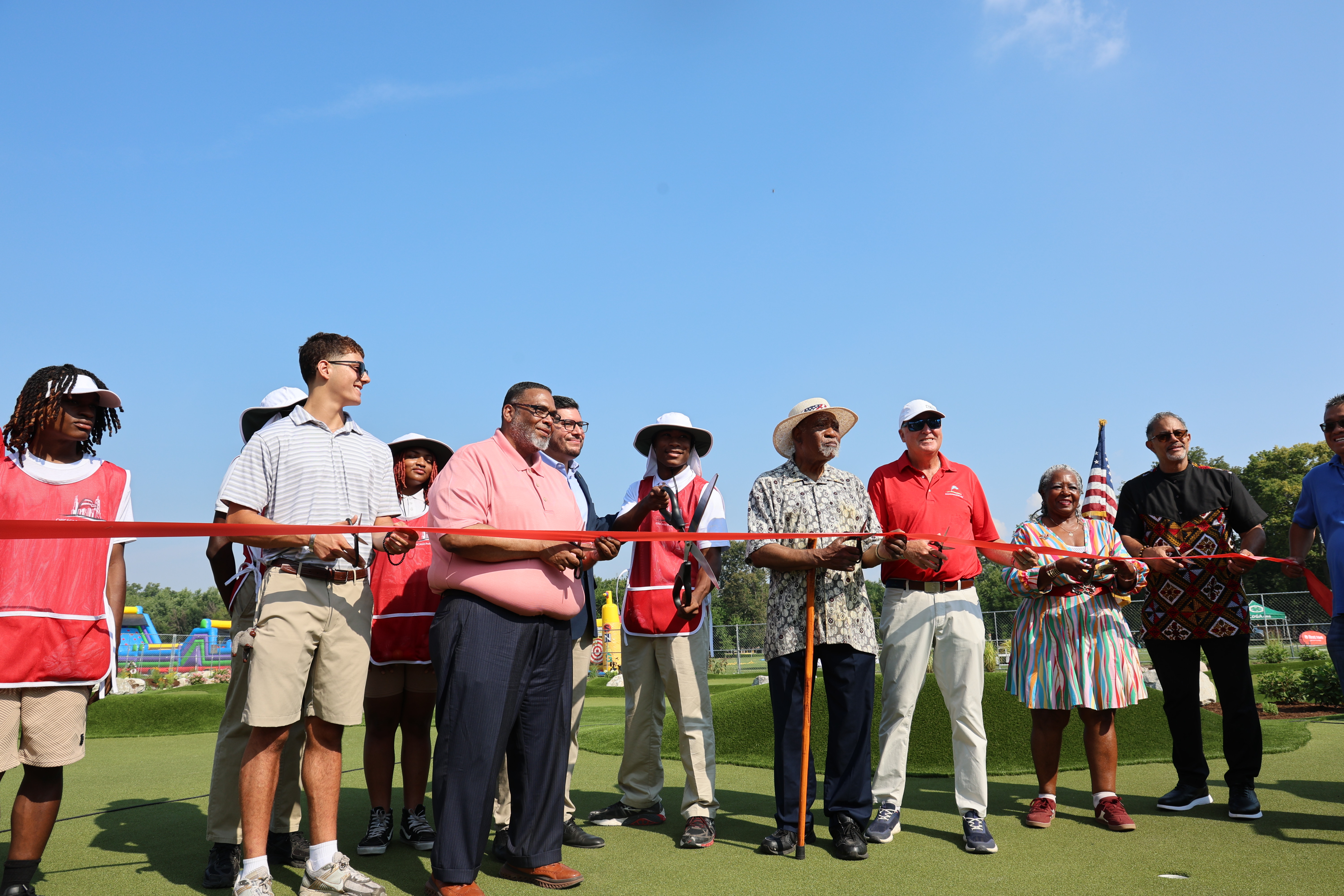 Group cuts a red ribbon at a grand opening ceremony.